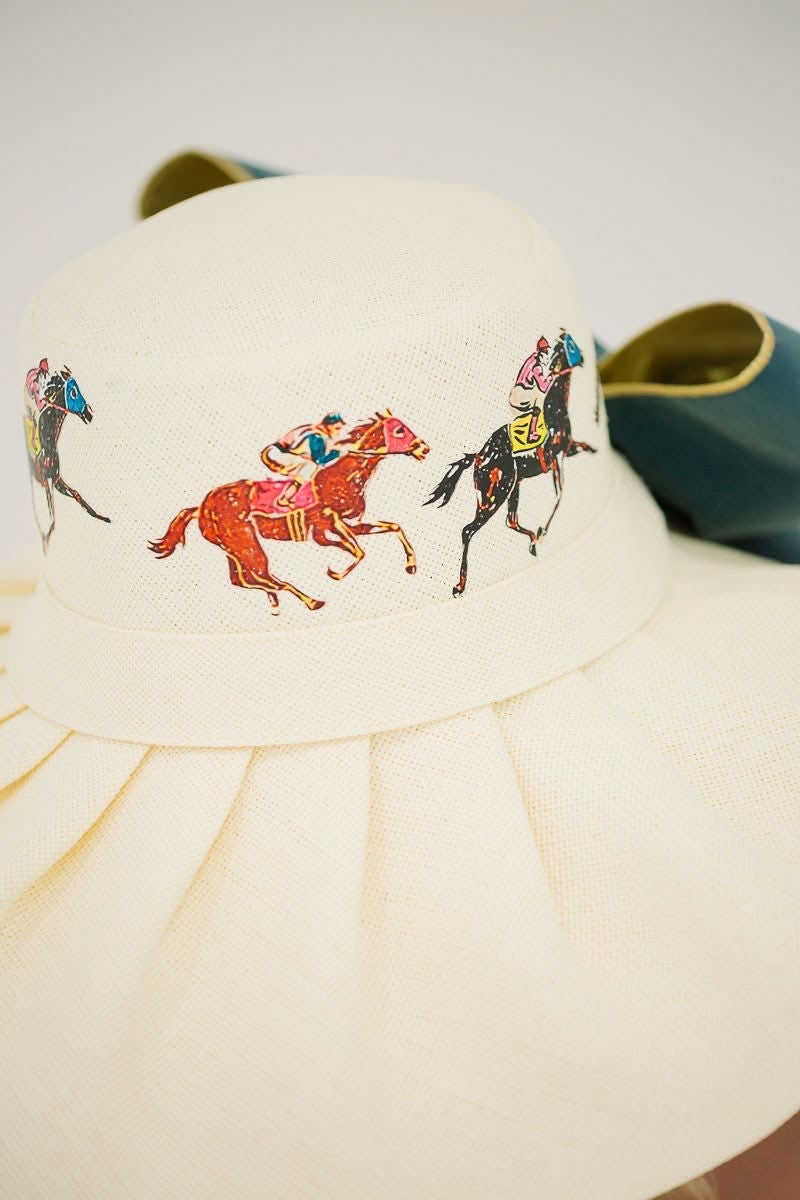 White sun hat with colorful horse and jockey designs on a white background