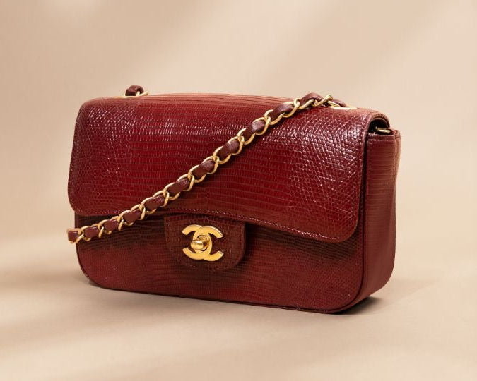 Chanel Red handbag with gold chain on a beige background